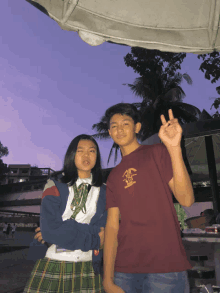 a boy and a girl pose for a picture and the girl is wearing a shirt that says ' california ' on it