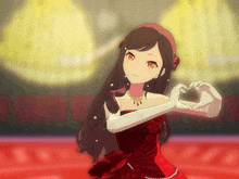 a girl in a red dress and white gloves is making a heart shape with her hands