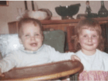 a boy and a girl are sitting next to each other and smiling