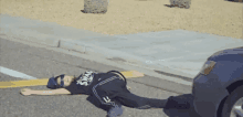 a person laying on the side of the road with a shirt that says swat on it