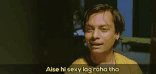 a man in a yellow shirt is making a funny face and saying `` aise hi sexy lag raha tha '' .