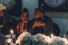 a man and a woman are sitting at a table with candles on it