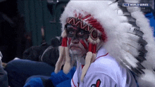 a man wearing a native american headdress is watching a fox world series