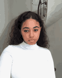 a young woman with curly hair is wearing a white turtleneck sweater