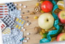 a wooden cutting board with fruits and vegetables and pills and a measuring tape