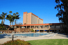 a large hotel with a large swimming pool in front of it