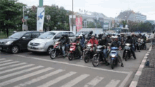 a bunch of people are riding motorcycles on a street .