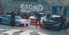 a group of men are posing for a picture in front of a wall that has the word shop on it