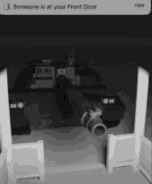 a black and white photo of a tank in a garage with a notification that someone is at the front door .