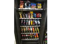 a vending machine filled with a variety of snacks including snickers and haribo