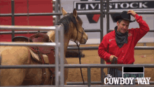 a man in a cowboy hat stands next to a horse in front of a sign that says " the cowboy way "