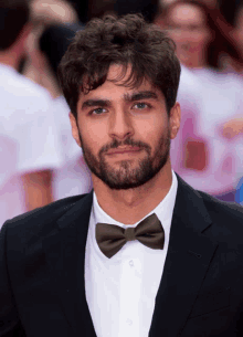 a man with a beard wearing a black suit and a bow tie