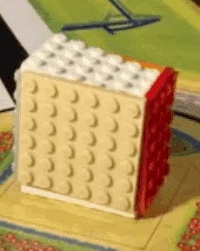 a lego block is sitting on a table next to a painting .