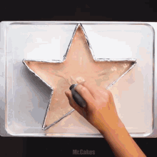 a person is making a cake in the shape of a star with mr.cakes written below it