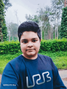 a boy wearing an oppo f11 pro sweatshirt poses for a photo