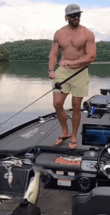 a shirtless man is standing on a boat holding a fishing rod