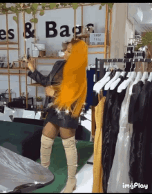 a woman with long orange hair is standing in front of a sign that says ' dresses & bags '