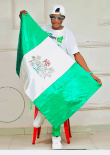 a person holding a green and white flag with the word independence on their shirt