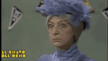 a woman wearing a blue hat and a purple dress with the words el chavo del ocho on the bottom right