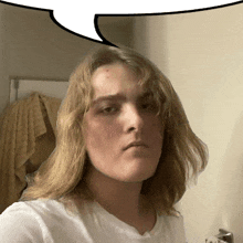 a young man with long blonde hair takes a selfie with a speech bubble above his head