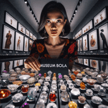 a woman in a museum holding a museum bola sign