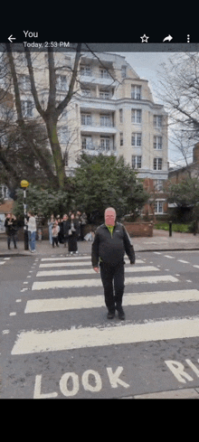 a man is crossing a road with a sign that says look right on it