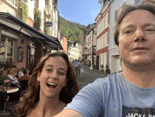 a man and a woman are posing for a picture in front of a building that has a sign that says albrecht