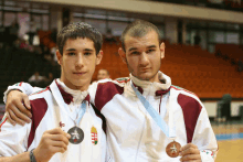 two athletes holding medals with a hungary flag on them