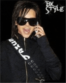 a woman wearing sunglasses is talking on a cell phone with a bk style logo behind her