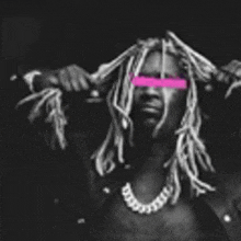 a black and white photo of a man with dreadlocks and a pink band on his eyes .