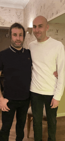 two men are posing for a picture with one wearing a white shirt