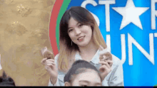 a woman is holding a cookie in front of a sign that says `` star run '' .