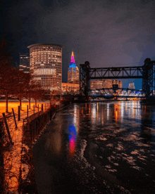 a bridge over a river with a city in the background