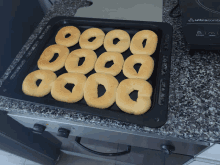 a tray of donuts sits on a granite counter next to a stove that says ultravox