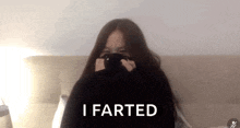 a woman is laying on a bed with her face covered and the words i farted in front of her