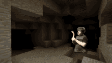 a man in a black shirt is holding a wooden stick in a dark cave