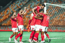 a group of soccer players are hugging each other and one of them has the number 10 on his jersey