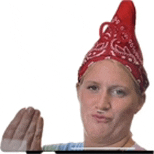 a woman wearing a red bandana and a red hat holds a toothbrush .