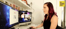 a woman sits at a desk in front of two computer monitors and a sign that says 60 seconds does on it