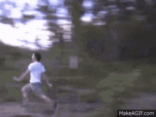 a man in a white shirt and shorts is running in a park