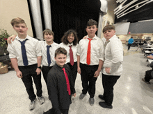 a group of boys wearing ties pose for a picture