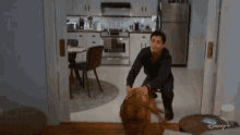 a man is petting a dog in a living room .