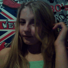 a girl stands in front of a wall with a british flag on it