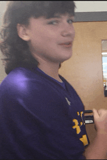 a person wearing a purple shirt with a yellow 3 on it