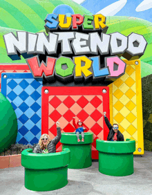 a super nintendo world sign with people sitting on green pipes