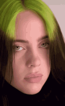 a close up of billie eilish 's face with green hair .