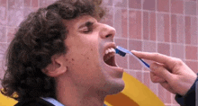 a man is brushing his teeth with a toothbrush