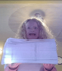 a young girl is holding a white towel in her hands