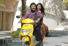 a man and a woman are riding a yellow scooter that says msd