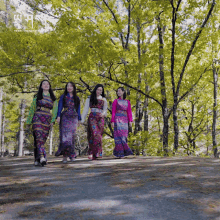 a group of women are walking down a path with trees in the background and a sign that says travel themed